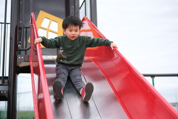 すべり台で遊ぶ男の子