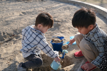 砂場で遊ぶ兄弟