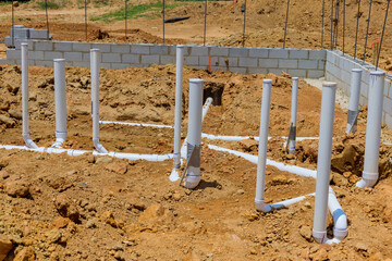 As part construction process under foundation of new home utility sewer pipes and water pipes must...
