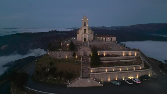 4k drone footage over Santuario da Senhora da Gra&ccedil;a at Mondim de Basto, Portugal, at sunset, above the clouds