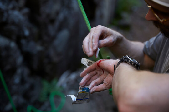 Rock climber putting plaster on injured hand