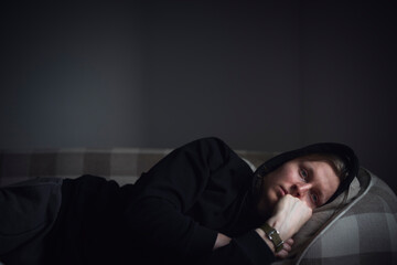 Sad man facing depression lying in bed