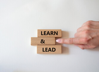 Learn and lead symbol. Concept words Learn and lead on wooden blocks. Beautiful white background. Businessman hand. Business and Learn and lead concept. Copy space.