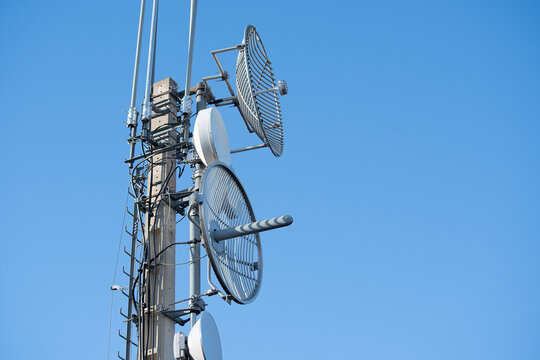 Tower with several round antennas, lightning rods and many cables