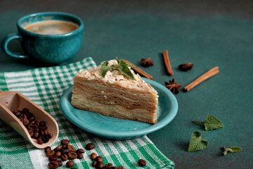 Layered Cake with cream Napoleon with mint on green background. Copy space