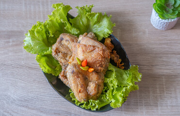 Breaded fried chicken in flower lettuce isolated on wooden background
