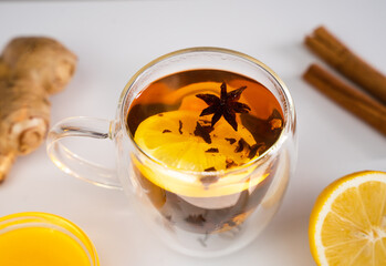 A tea with lemon, ginger and spices for breakfast on the table. Vitamin tea in the morning. Close-up. Selective focus.