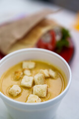 Gourmet champignon soup with crusty croutons served in white bowl in fast food restaurant. Healthy eating concept