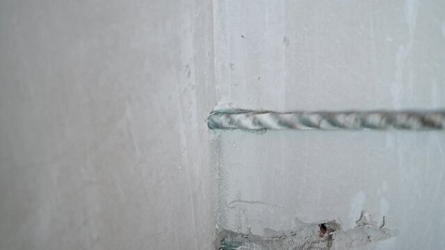 Close up Drilling for laying air conditioning pipes through the wall. Builder drills reinforced concrete with a heavy duty powerful hammer drill