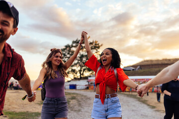 Young cheerful couples having fun at music festival