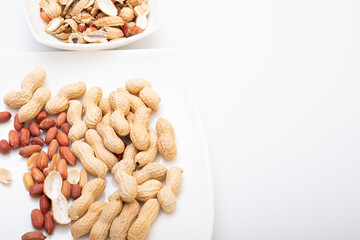 Peanuts in shell isolated on white background. Heap of peanuts close up	