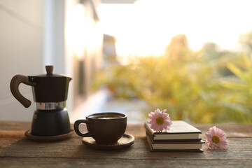 Black coffee cup and moka pot and notebook diary and pink Chrysanthemum flowers