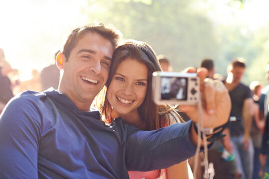 That festival feeling. a young couple taking a self-portrait together at an outdoor event.