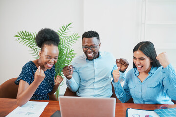 Three smiling and happy coworkers cheer and celebrate success, looking at screen