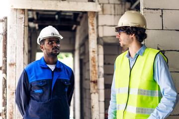 Professional of team architect industrial engineer cargo foreman in helmet working new construction project architectural plan and construction tool on table at the building construction site
