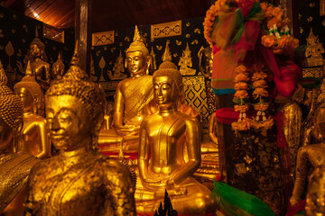 Golden group buddha faces statue meditation sitting with a Golden Buddha background up down and sitdown.