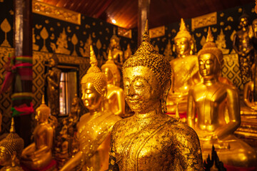 Golden group buddha faces statue meditation sitting with a Golden Buddha background up down and...