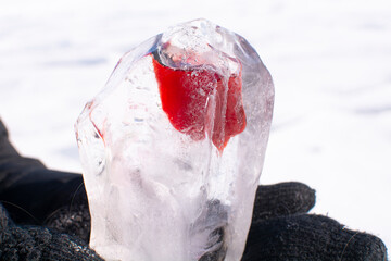 ice cubes with hole and red drink. Popular tourist attraction during winter time aka Baikal Kiss