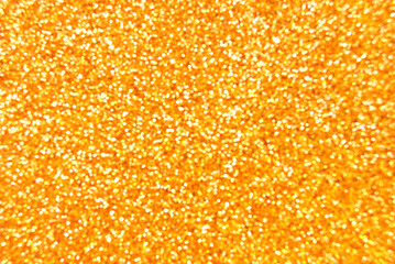 Golden defocused glitter texture as background
