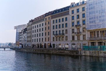 Naklejka premium Rhone River scenic view of facades at Swiss City of Geneva on a sunny winter day. Photo taken March 5th, 2023, Geneva, Switzerland.