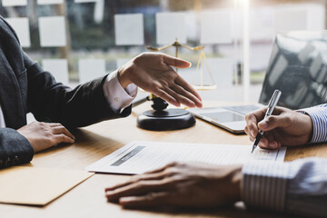 Female lawyer is explaining the terms of the legal contract document and asking the client to sign it properly.