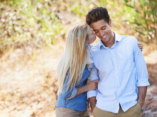 Fototapeta premium Youre my Prince Charming. a beautiful young woman kissing her boyfriend on the cheek while spending time together outdoors.