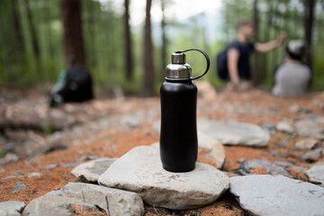 steel bottle of water in the forest	