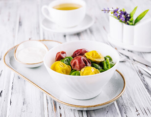 Cooked multi-colored tortellini dumplings close-up in a bowl