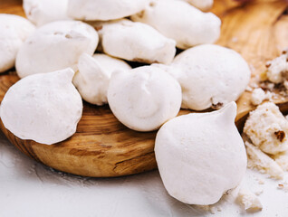 Fresh meringue cookies on wooden board
