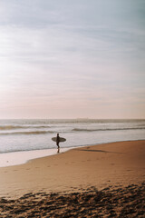 Silueta de surfista entrando en el agua al atardecer en playas de andalucia