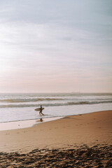 Silueta de surfista entrando en el agua al atardecer en playas de andalucia