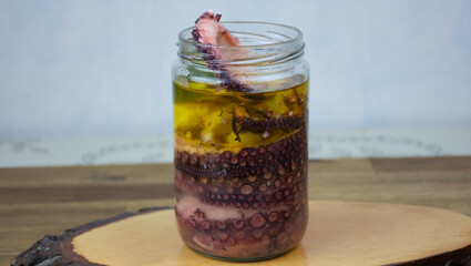 Close up view of  sliced octopus marinated in olive oil in a glass jar