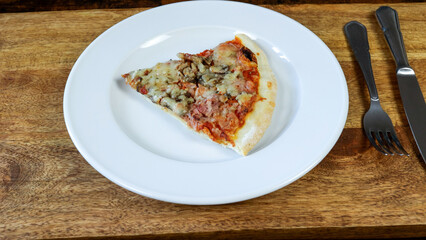 part de pizza, en gros plan, dans une assiette