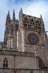 Fototapeta na wymiar La Catedral de Burgos y sus vidrieras y columnas bajo un cielo azul con nubes en un día de primavera.