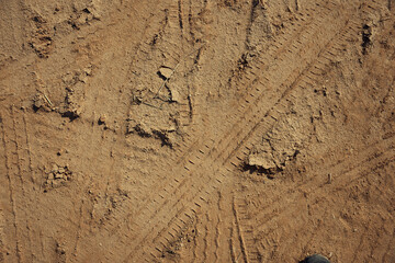 Dirt gravel road with tire tracks texture at the construction site