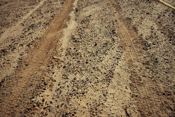 Dirt gravel road with tire tracks texture at the construction site
