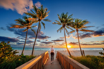 Woman enjoying Sunrise,walking to the Beach,taking Photos with the Phone,.Hollywood Beach,Hollywood,Miami .Floridas East Coast.Miami Beach,Miami Florida USA