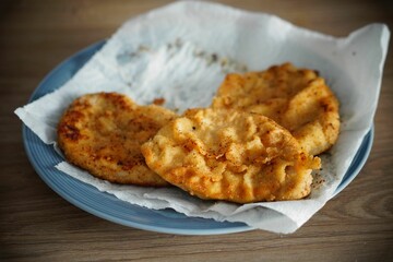 Closeup of deep-fried chicken breast served on a blue plate