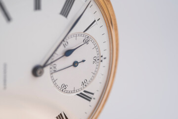 Vintage gold pocket watch on an open old book.