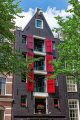 Amsterdam street in summer with colorful houses in classic holland architecture