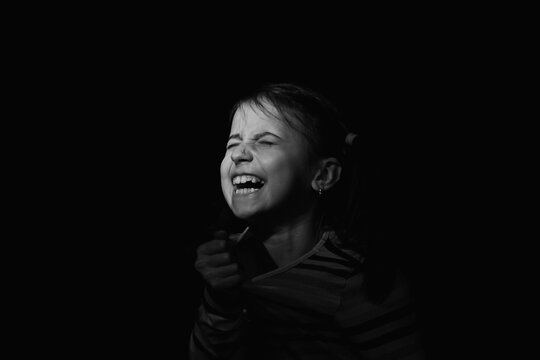 Conceptual image : mental health, stress, depression, panic attacks and anxiety in children. Nervous young girl screams for help.. Black and white image.