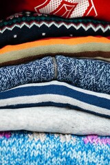 Vertical shot of folded sweaters stacked on each other