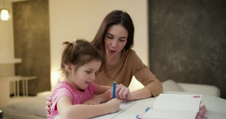 Mother and her preschool daughter do homework together at home