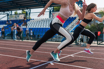 Obraz premium Two athlete young woman runnner on the start at the stadium outdoors