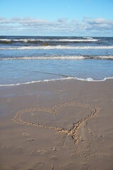 Charming Ahlbeck seascape with a heart on wet sand sunny day