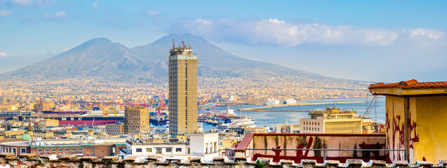 Naples, Italy. Top view, from Corso Vittorio Emanuele street. In the distance Mount Vesuvius and the Port of Naples. In the foreground some buildings and houses roofs. Banner Header Image. 2023-01-03.
