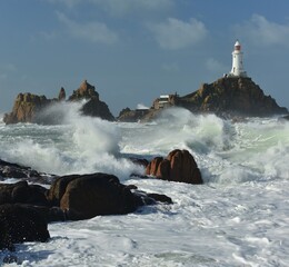 La Corbiere lighthouse, Jersey, U.K. Morning coastal Spring tides with dramatic stormy weather.