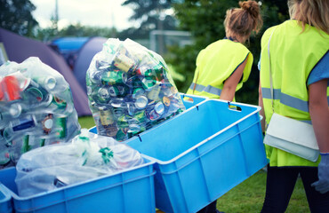 Cleaning up the aftermath of the festival. two young women picking up trash after a festival.