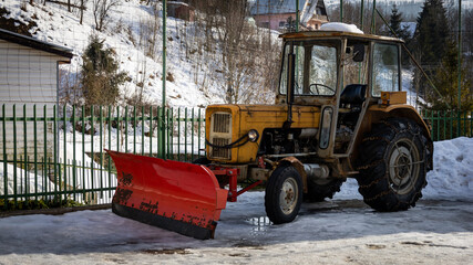 traktor z łyżką do odśnieżania śniegu
