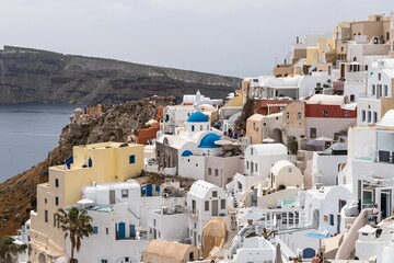 Churches with blue domes and white houses in Oia overlooking the sea